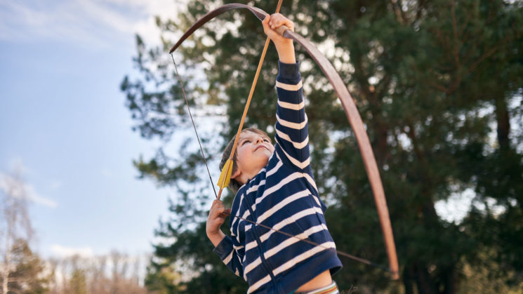 boy aiming bow and arrow.