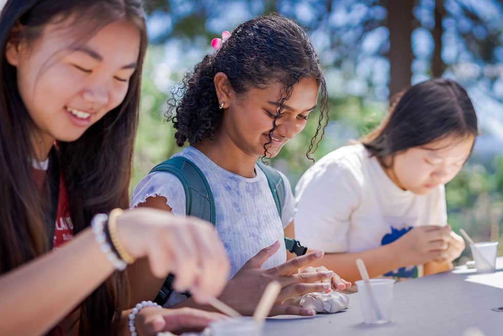 Students working together on a hands-on activity at an outdoor table at Pali Institute