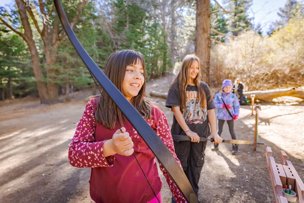 A student drawing a bow at the archery range at Pali Institute