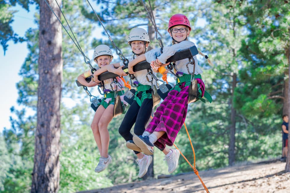 Students in helmets and harnesses on the ropes course at Pali Institute