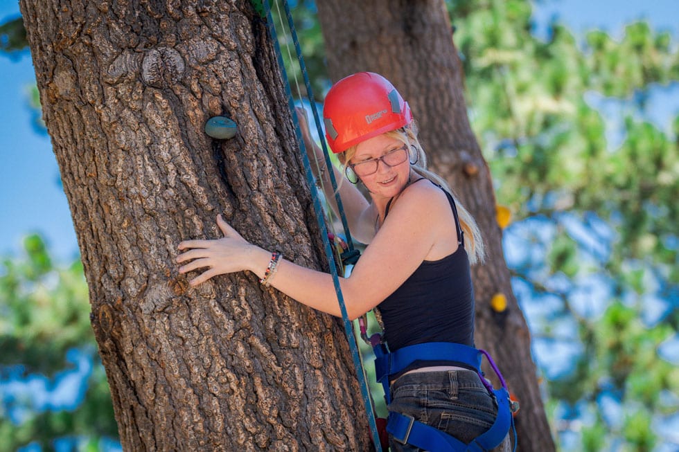 A student in a helmet and harness climbing during a supervised activity at Pali Institute